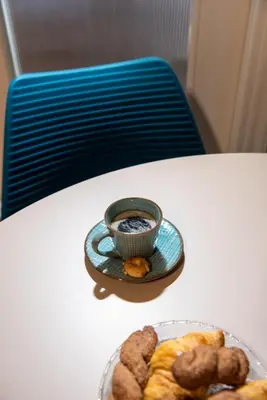 a table with a cup of coffee and a plate of donuts at Blue Ark Acropolis Spirit in Athens