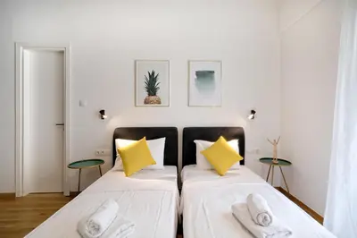 a bedroom with two beds with yellow pillows at Elegant Big Apartment in Athens Center With Balcony in Athens