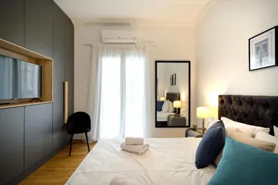 a bedroom with a large white bed with a window at Elegant Big Apartment in Athens Center With Balcony in Athens