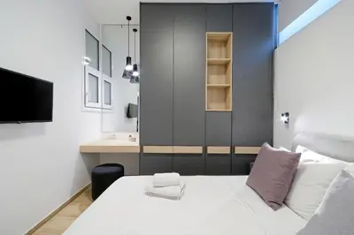 a bedroom with a white bed and a television at Elegant Big Apartment in Athens Center With Balcony in Athens