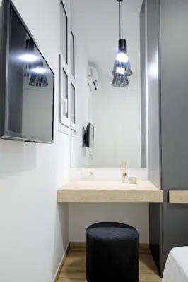 a bathroom with a vanity with a tv and a stool at Elegant Big Apartment in Athens Center With Balcony in Athens