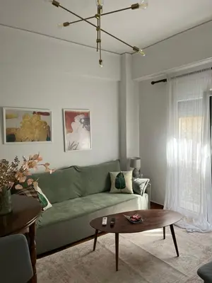 a living room with a green couch and a table at Alex’s home next to Laiko in Athens