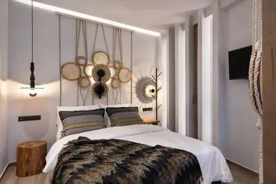 a bedroom with a large white bed with a wooden stumpemate at Olympiou at Heart of Koukaki in Athens