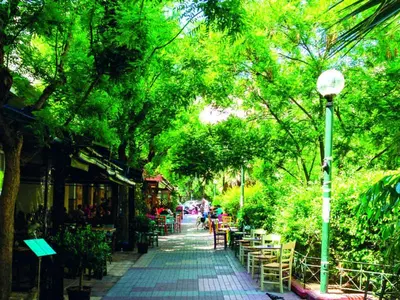 a street with tables and chairs and a street light at Olympiou at Heart of Koukaki in Athens