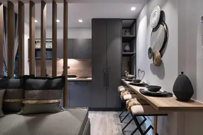 a living room with a table and a kitchen at Olympiou at Heart of Koukaki in Athens