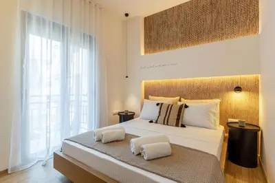 a bedroom with a large bed and a large window at IO SUITES in Athens