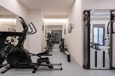 a gym with a row of treadmills and ellipticals at IO SUITES in Athens