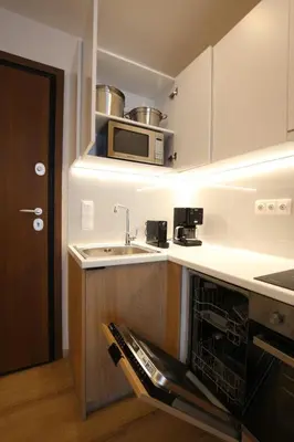 a kitchen with a sink and a microwave at IO SUITES in Athens