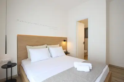 a bedroom with a large white bed with white pillows at IO SUITES in Athens