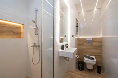a bathroom with a shower and a sink and a toilet at IO SUITES in Athens