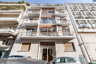 an apartment building with cars parked in front of it at Cozy apartment in Kolonaki Athens - Sleeps 5 in Athens