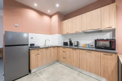 a kitchen with wooden cabinets and a refrigerator at Rest Sleep Repeat by museum-1 in Athens