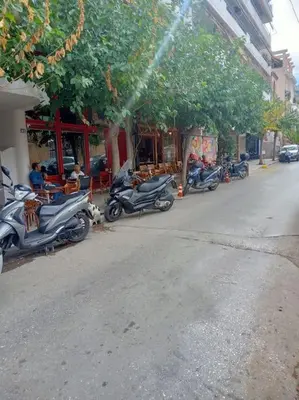 a row of scooters parked on the side of a street at Urban comfort apartment. in Athens