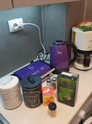 a counter top with a coffee maker and other items on it at Urban comfort apartment. in Athens