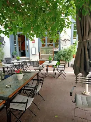a patio with tables and chairs under a tree at Urban comfort apartment. in Athens