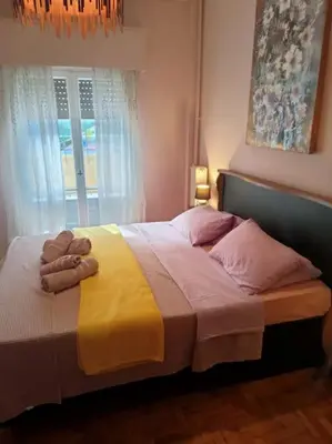 a bedroom with a bed with a yellow blanket and a window at Urban comfort apartment. in Athens