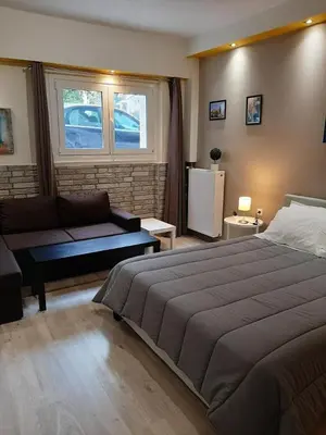 a bedroom with a large bed and a couch at Byronico Acropolis Apartment by MPS in Athens