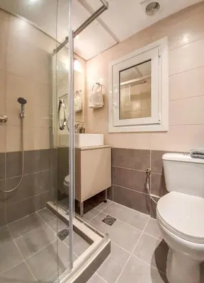 a bathroom with a shower and a toilet and a sink at Byronico Acropolis Apartment by MPS in Athens