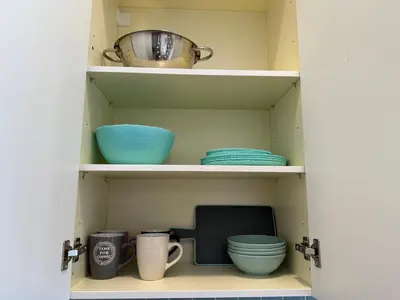 a cupboard with plates and bowls and a pot at A13 Athens in Athens