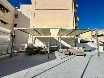 a patio with chairs and umbrellas on a building at A13 Athens in Athens
