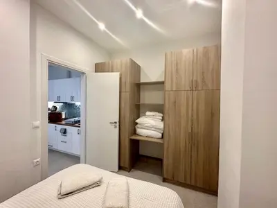 a bedroom with a bed and a closet with towels at A13 Athens in Athens