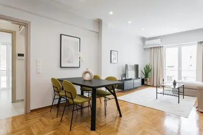 a dining room with a black table and yellow chairs at Remarkable 2BR Apartment in Paleo Faliro by UPSTREET in Athens