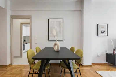 a dining room with a black table and yellow chairs at Remarkable 2BR Apartment in Paleo Faliro by UPSTREET in Athens