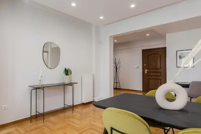 a living room with a black table and yellow chairs at Remarkable 2BR Apartment in Paleo Faliro by UPSTREET in Athens