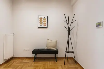a white room with a bench and a plant at Remarkable 2BR Apartment in Paleo Faliro by UPSTREET in Athens
