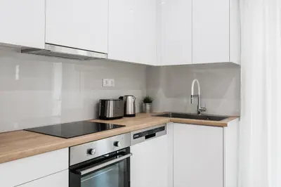 a kitchen with white cabinets and a sink at Remarkable 2BR Apartment in Paleo Faliro by UPSTREET in Athens