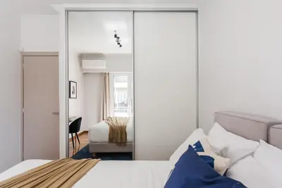 a bedroom with a bed and a mirror at Remarkable 2BR Apartment in Paleo Faliro by UPSTREET in Athens