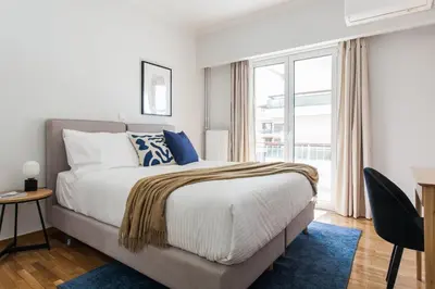 a bedroom with a bed and a large window at Remarkable 2BR Apartment in Paleo Faliro by UPSTREET in Athens