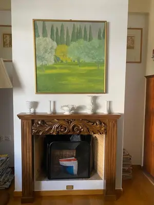 a fireplace in a living room with a painting on the wall at Traditional And Spacious Apartment In Neo Psychiko in Athens