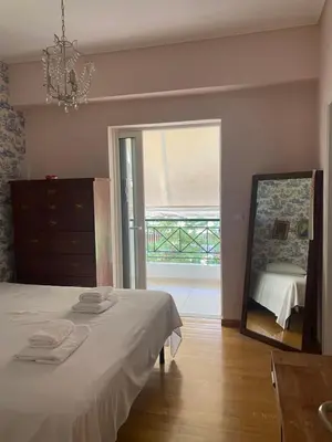 a bedroom with a bed and a mirror and a window at Traditional And Spacious Apartment In Neo Psychiko in Athens