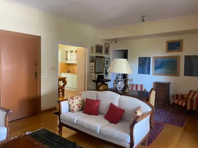 a living room with a white couch with red pillows at Traditional And Spacious Apartment In Neo Psychiko in Athens