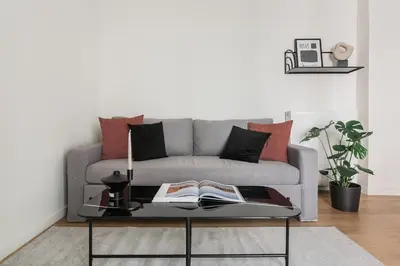 a living room with a couch and a table with books at Striking Apartments in Kolonaki by UPSTREET in Athens