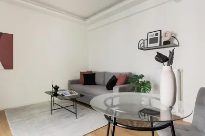 a living room with a couch and a glass table at Striking Apartments in Kolonaki by UPSTREET in Athens