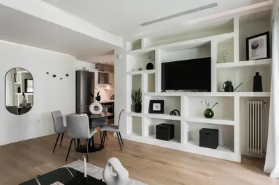 a living room with white walls and a flat screen tv at Striking Apartments in Kolonaki by UPSTREET in Athens