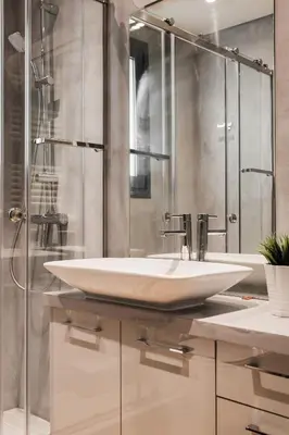 a bathroom with a white sink and a shower at Striking Apartments in Kolonaki by UPSTREET in Athens