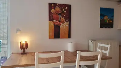 a dining room table with chairs and a painting on the wall at \u5c71\u811a\u4e0b\uff0c\u8212\u9002\u6e29\u99a8\u6d77\u666f\u516c\u5bd3 in Athens