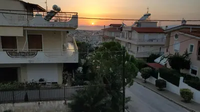 a view of a street with houses and a sunset at \u5c71\u811a\u4e0b\uff0c\u8212\u9002\u6e29\u99a8\u6d77\u666f\u516c\u5bd3 in Athens