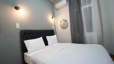 a bedroom with a large white bed with a window at Athens City Themis13 in Athens