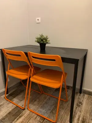 two orange chairs sitting at a black table with a plant at Athens City Themis 6 in Athens