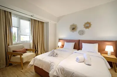 a bedroom with a bed with a cat laying on it at Triplex Villa Gardenia Glyfada sea view in Athens
