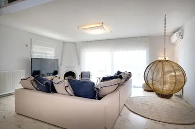 a living room with a couch and a large window at Triplex Villa Gardenia Glyfada sea view in Athens