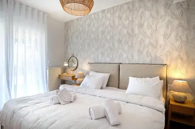 a bedroom with a large white bed with two pillows at Triplex Villa Gardenia Glyfada sea view in Athens