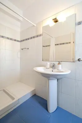 a white bathroom with a sink and a mirror at Triplex Villa Gardenia Glyfada sea view in Athens