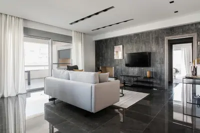 a living room with a white couch and a television at Teal Faliro House by UPSTREET in Athens