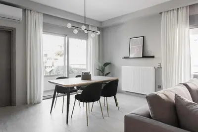 a dining room with a table and chairs and a couch at Teal Faliro House by UPSTREET in Athens