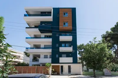 a tall building with white and blue at Teal Faliro House by UPSTREET in Athens
